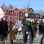 Uczestnicy uroczystości składają kwiaty pod pomnikiem upamiętniającym mieszkańców Ziemi Pułtuskiej pomordowanych i poległych w okresie II wojny światowej